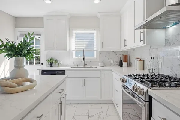 a kitchen with white cabinets and a stove