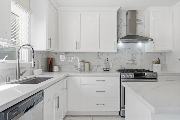 a kitchen with granite countertop white cabinets and a stove