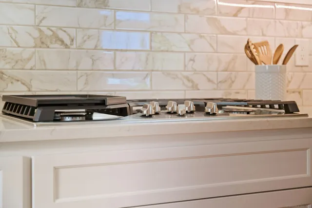a kitchen with granite countertop white cabinets and stainless steel appliances