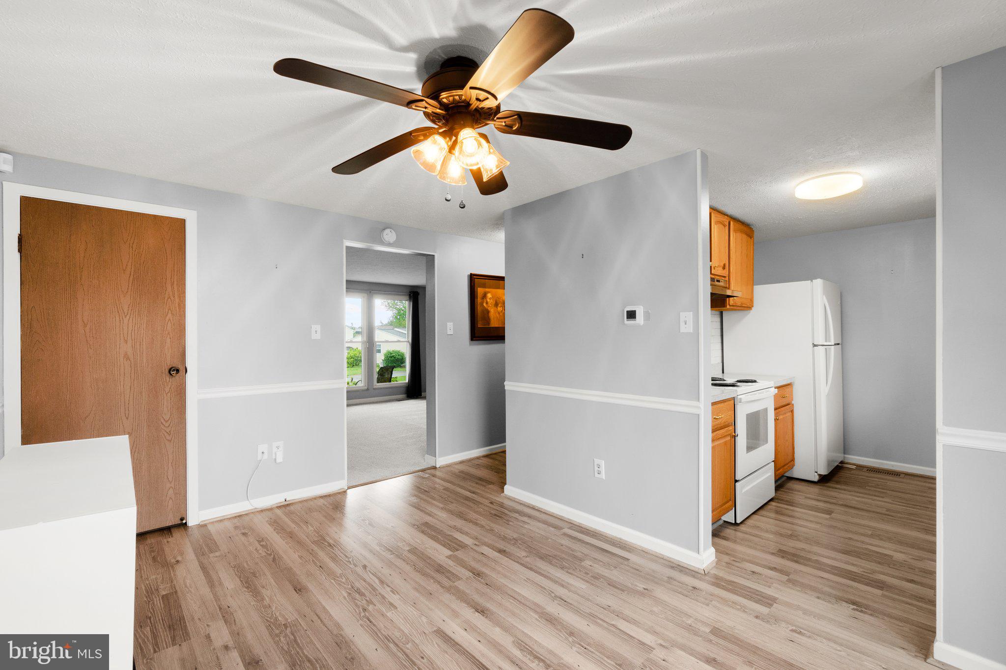 436 Heather Ridge Drive Frederick, MD 21702 - Photo 6 of 30 a view of a kitchen with a refrigerator a ceiling fan wooden floor and an entryway
