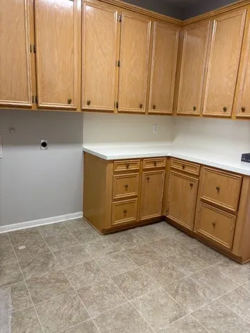 a view of a kitchen with wooden cabinets
