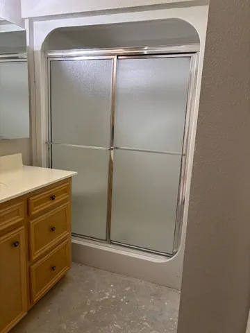 a bathroom with a glass shower door