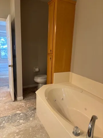 a white bath tub sitting next to a toilet