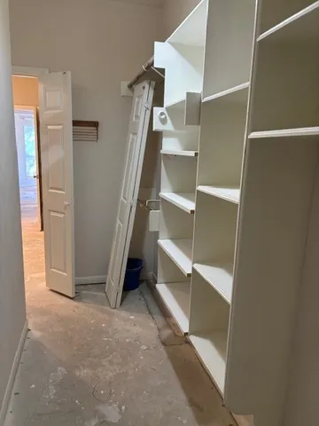 a view of walk in closet with empty racks