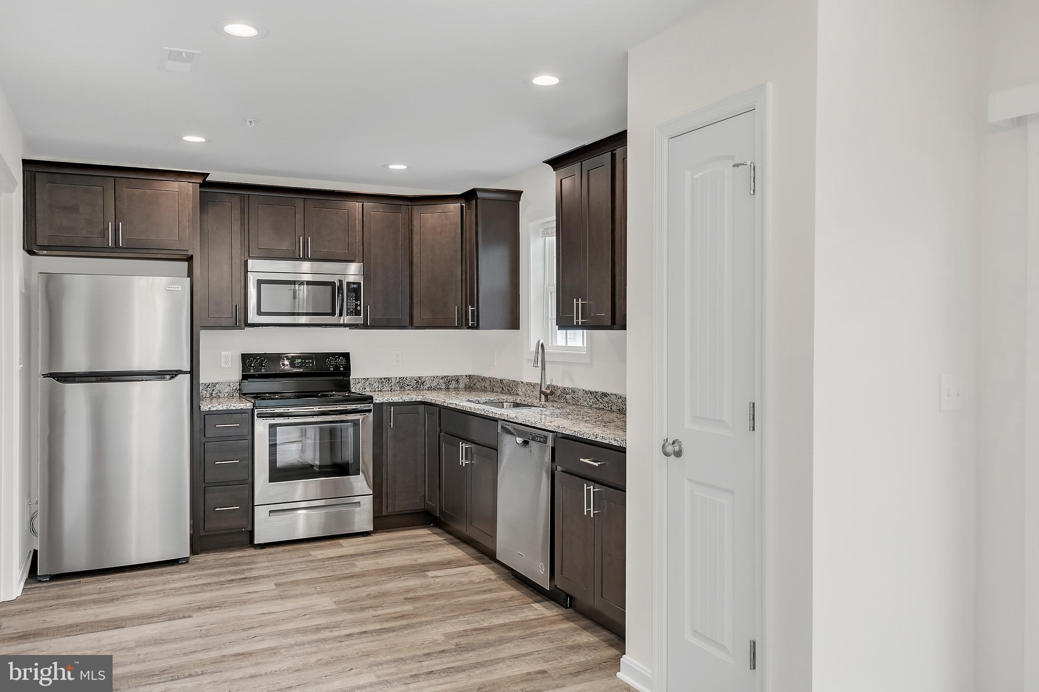 414 Valor Way Red Lion, PA 17356 - Photo 6 of 22 a kitchen with kitchen island granite countertop stainless steel appliances and wooden cabinets