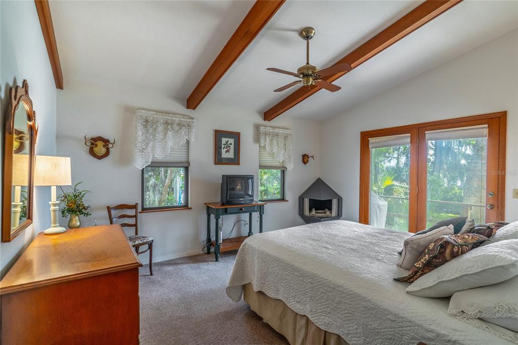 121 North Lake George Drive Georgetown, FL 32139 - Photo 24 of 46 a bed sitting in a bedroom next to a window with a chandelier and dresser