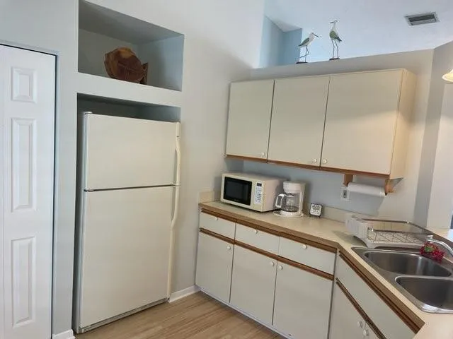 a kitchen with a refrigerator sink and cabinets