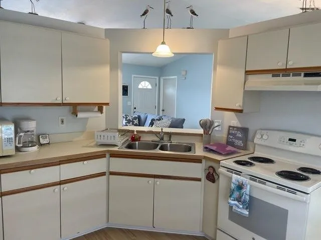 a kitchen with a sink a stove and cabinets