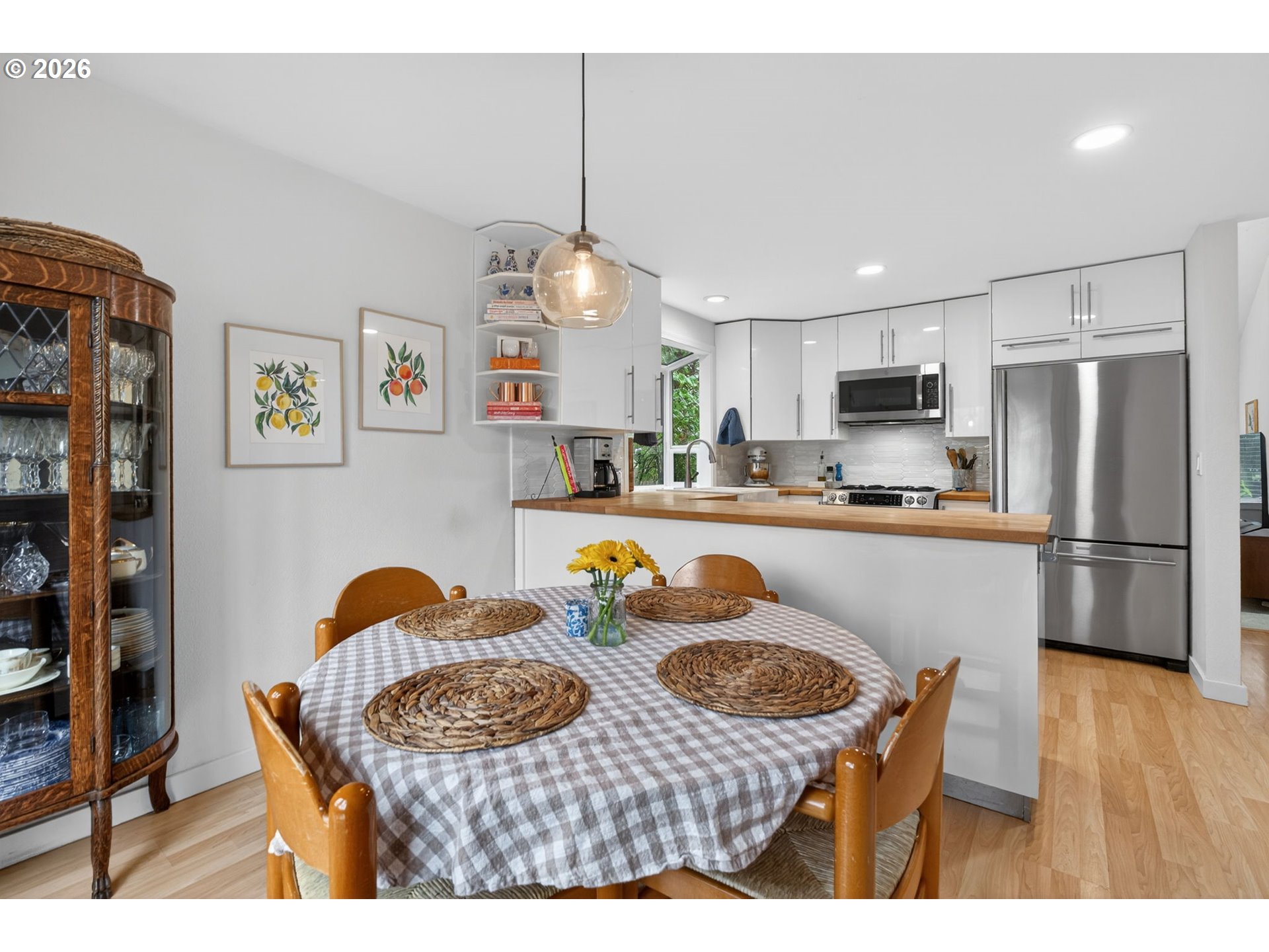 8115 Southwest Hemlock Street Portland, OR 97223 - Photo 11 of 36 a kitchen with stainless steel appliances granite countertop a refrigerator a stove a sink dishwasher a dining table and chairs with wooden floor