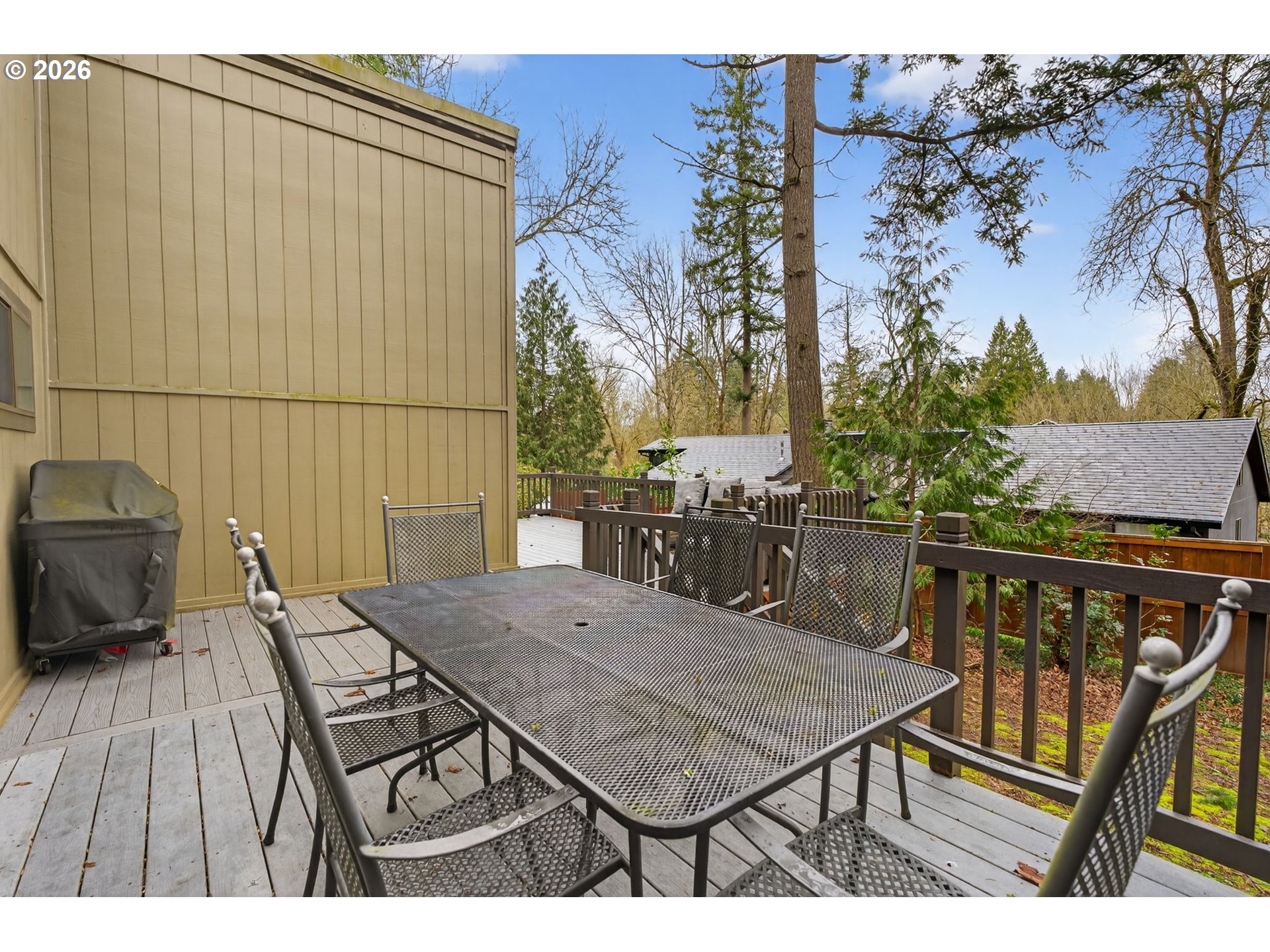 8115 Southwest Hemlock Street Portland, OR 97223 - Photo 30 of 36 a view of a roof deck with table and chairs with wooden floor and fence