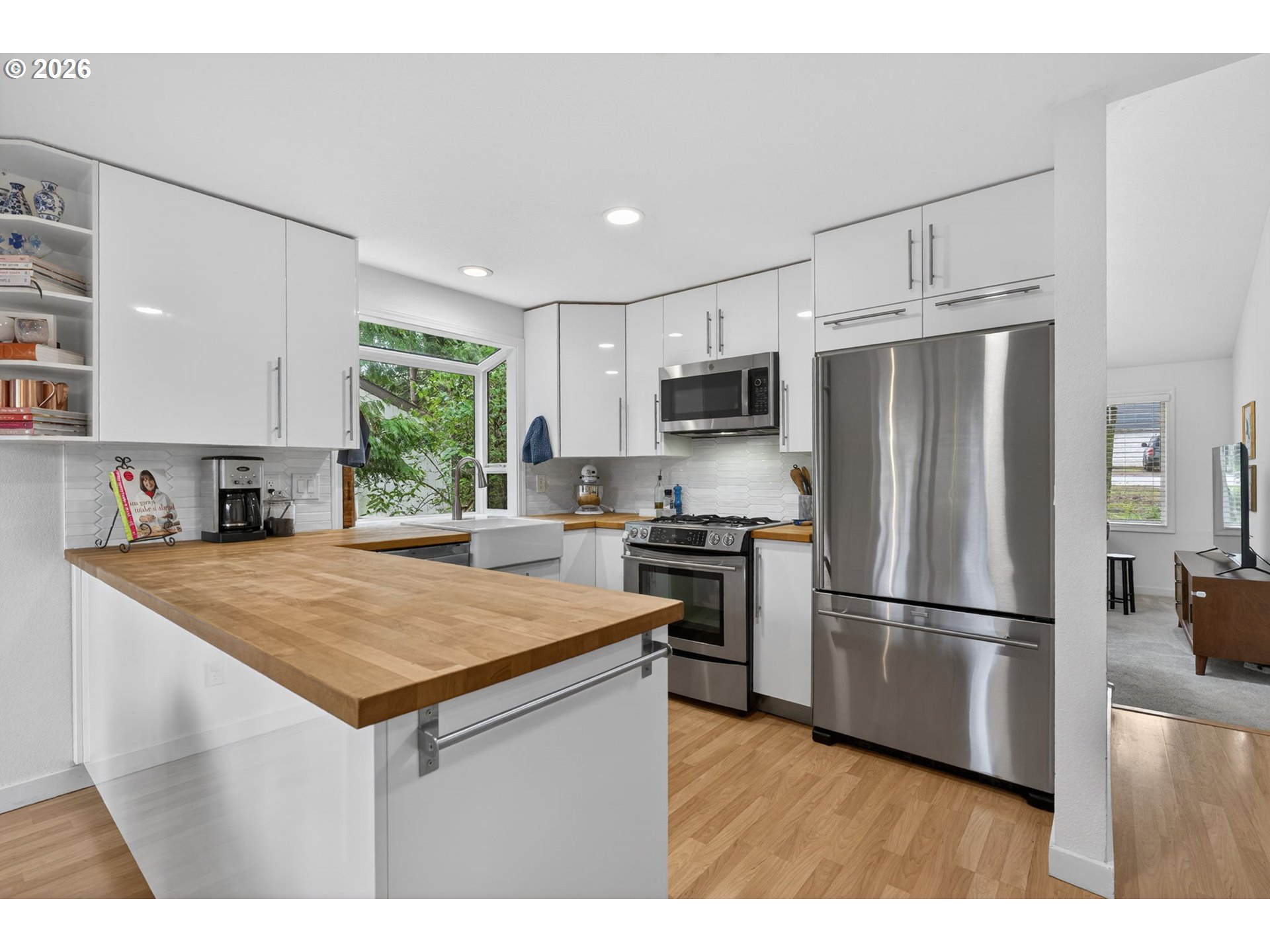 8115 Southwest Hemlock Street Portland, OR 97223 - Photo 7 of 36 a kitchen with kitchen island a refrigerator stove a sink dishwasher and microwave with wooden floor