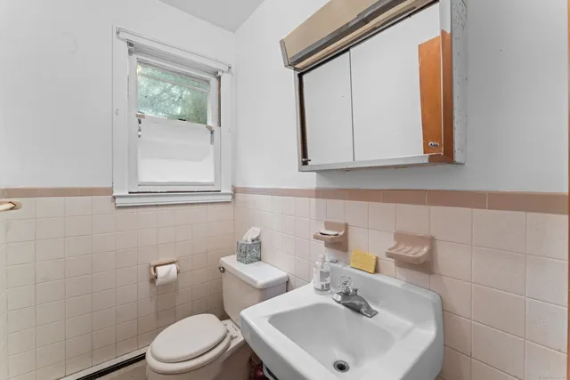 a bathroom with a sink a toilet and mirror