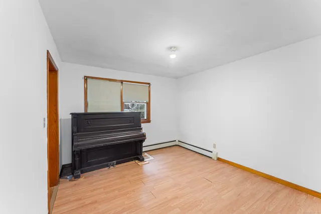 a view of room with wooden floor and a window