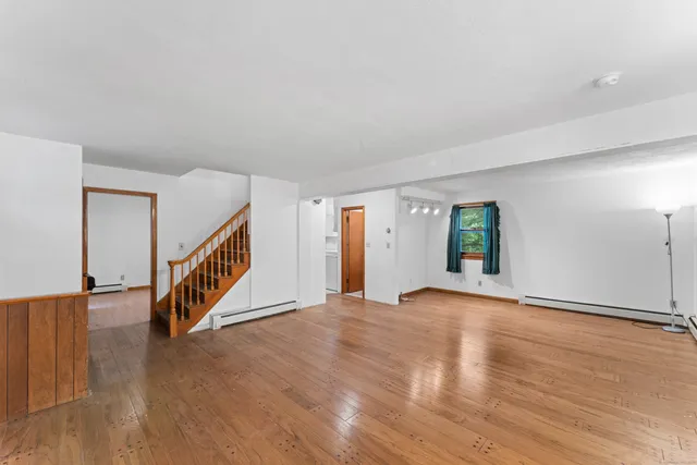 a view of an empty room with wooden floor