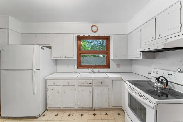 a kitchen with white cabinets and white appliances