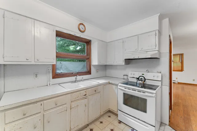 a kitchen with granite countertop white cabinets white stainless steel appliances and a sink