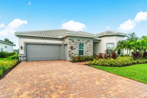 a front view of a house with a garden and garage