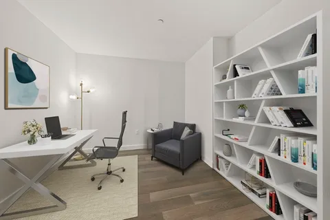 a work room with furniture a book shelf and a shelf