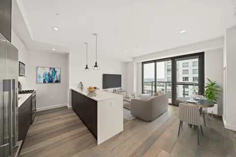 a large living room with stainless steel appliances granite countertop a couch and a table