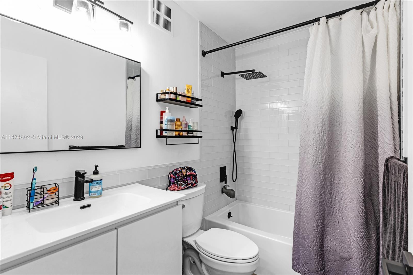 6825 Southwest 45th Lane, Unit 1 Miami, FL 33155 - Photo 17 of 28 a bathroom with a sink a toilet and shower curtain