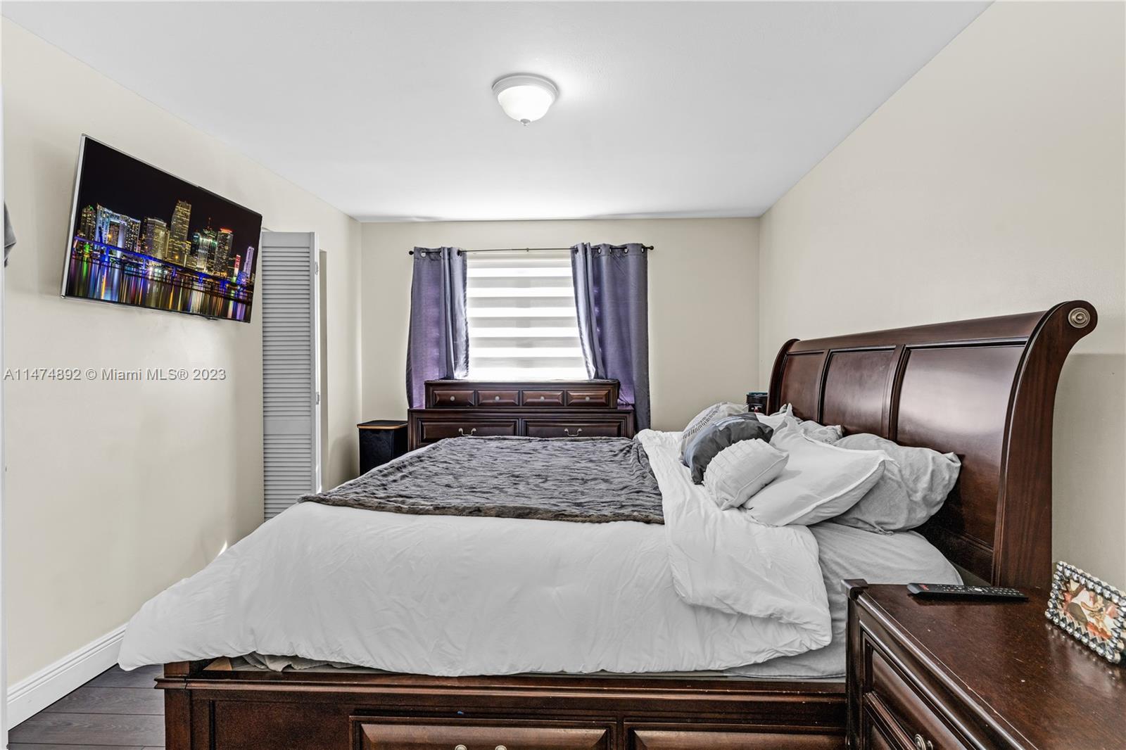 6825 Southwest 45th Lane, Unit 1 Miami, FL 33155 - Photo 19 of 28 a bedroom with a bed and a flat screen tv