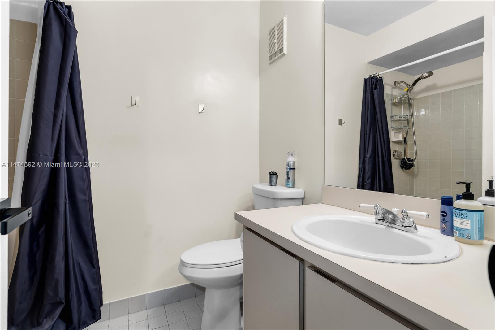 6825 Southwest 45th Lane, Unit 1 Miami, FL 33155 - Photo 21 of 28 a bathroom with a sink a toilet and a mirror