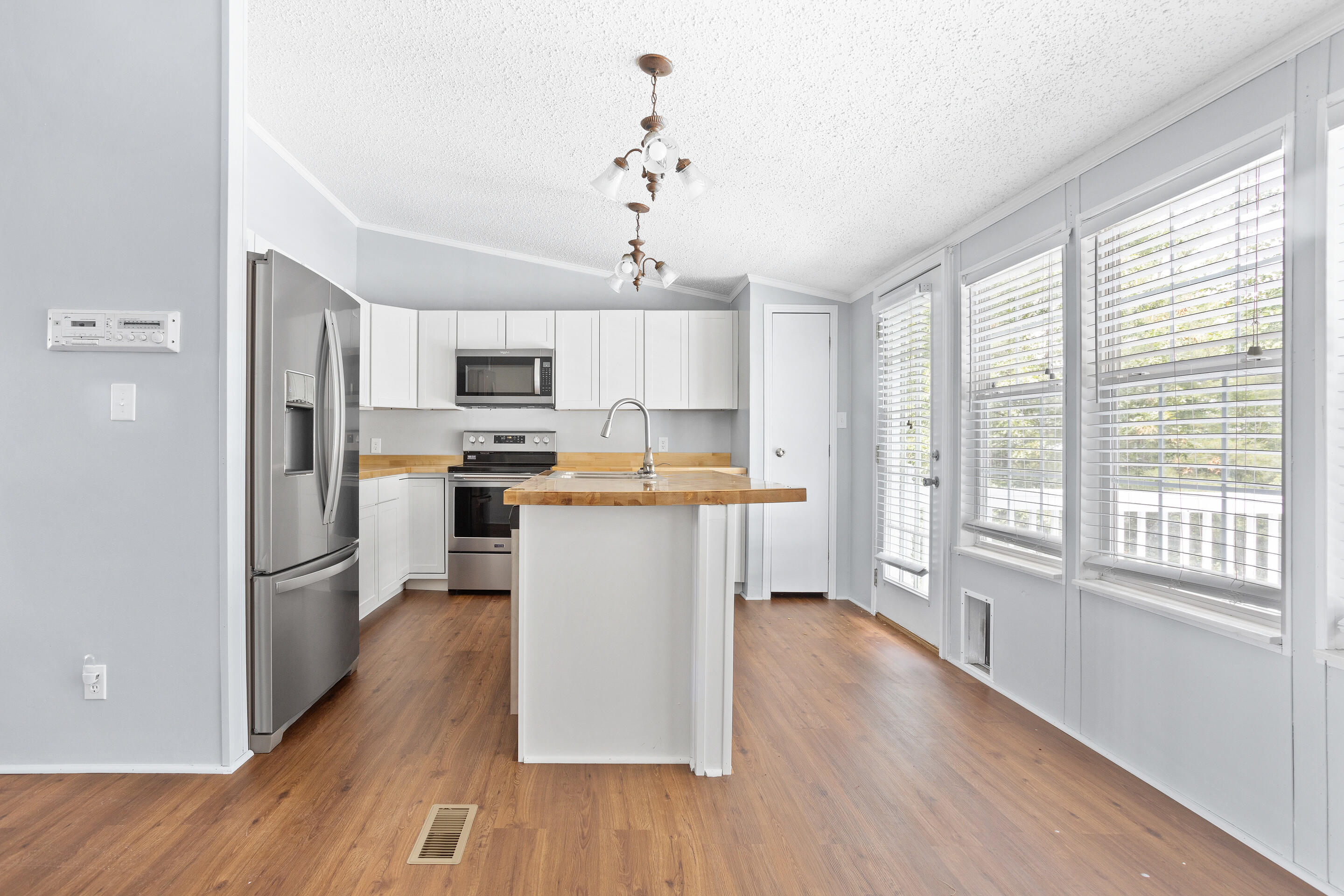910 Dobbins Hollow Road Riner, VA 24149 - Photo 15 of 35 a kitchen with stainless steel appliances granite countertop a refrigerator a stove top oven a sink dishwasher and white cabinets with wooden floor