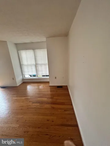 a view of a room with wooden floor and window