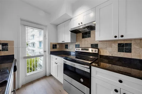 a kitchen with stainless steel appliances granite countertop a sink and a stove