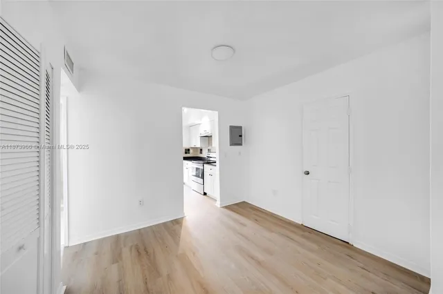 a view of an empty room with wooden floor