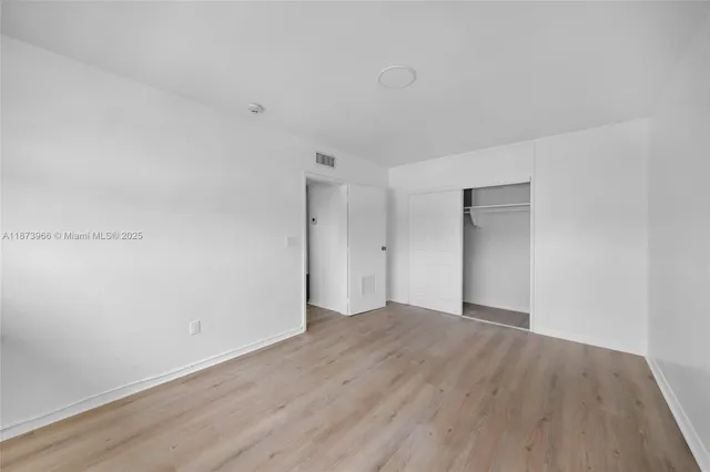 an empty room with wooden floor and white walls