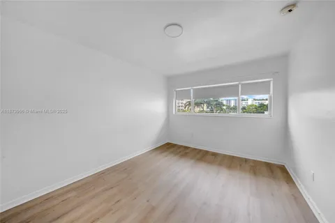 a view of a room with wooden floor and white walls