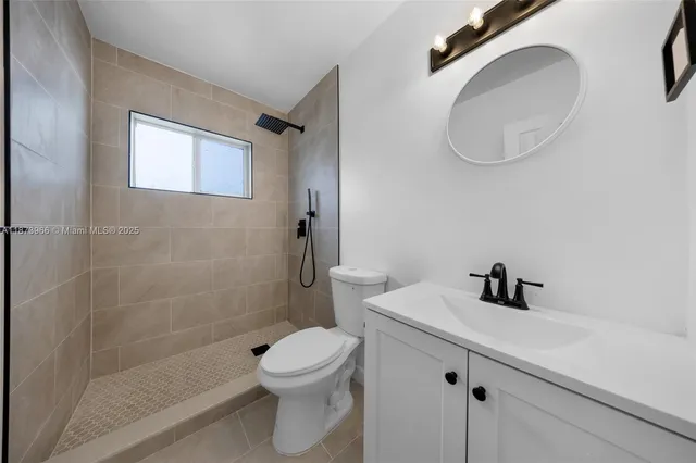 a white toilet sitting next to a bathroom sink