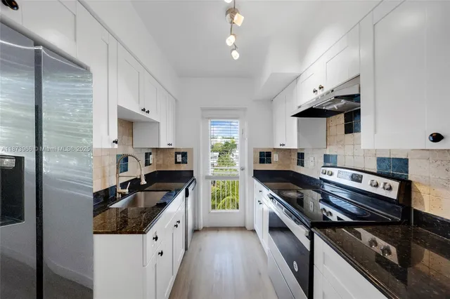 a kitchen with stainless steel appliances granite countertop a stove and a microwave