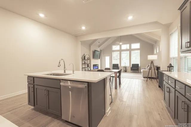 a living room with a sink and a large mirror with wooden floor