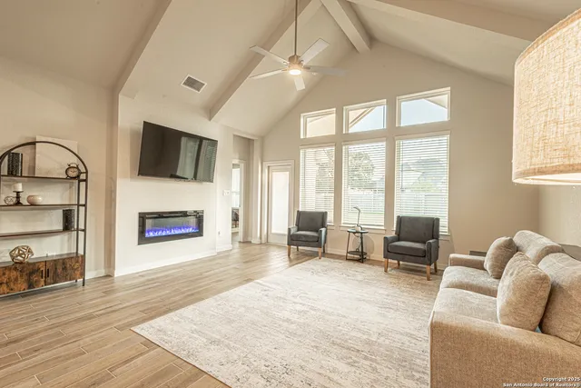 a living room with furniture a fireplace and a flat screen tv