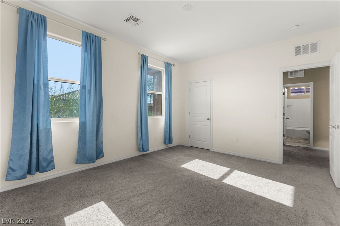 11048 Prairie Grove Road Las Vegas, NV 89179 - Photo 57 of 75 Sun-filled room featuring plush gray carpeting and multiple windows.