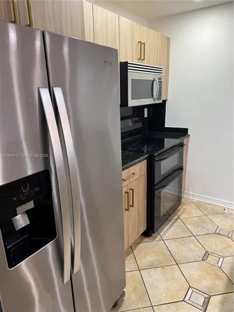 a kitchen with granite countertop a refrigerator stove and microwave