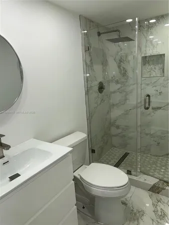 a bathroom with a toilet a sink and shower
