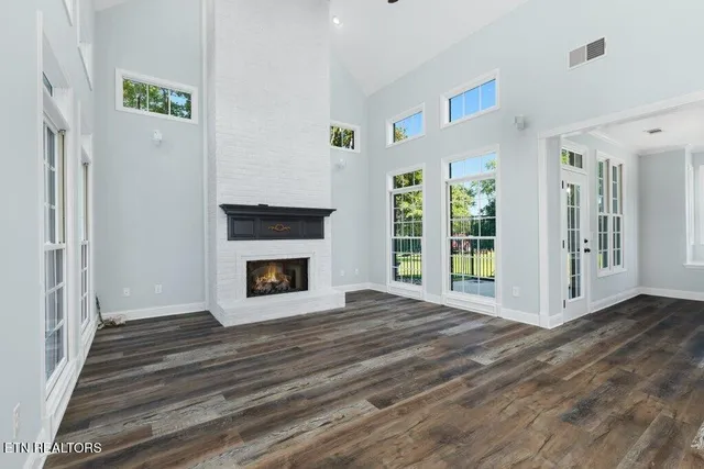 a view of empty room with wooden floor and ceiling fan