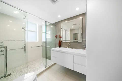 a bathroom with a double vanity sink mirror and shower