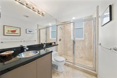 a bathroom with a sink a toilet a mirror and a shower