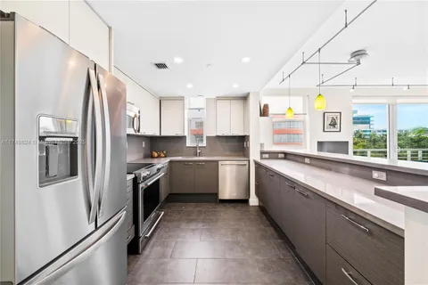 a kitchen with a sink stainless steel appliances cabinets and a window
