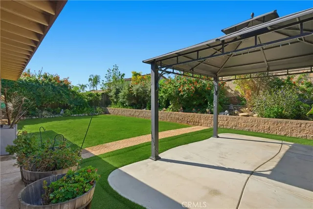 a view of a backyard with table and chairs under an umbrella