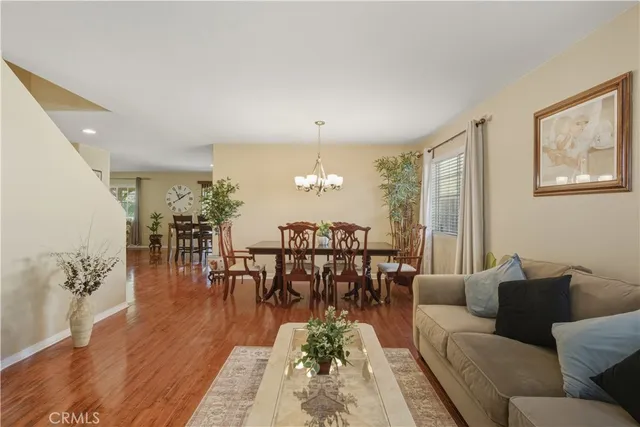 a living room with furniture wooden floor and a chandelier