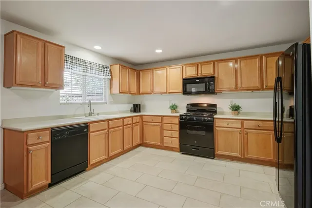 a kitchen with granite countertop a stove top oven sink and cabinets