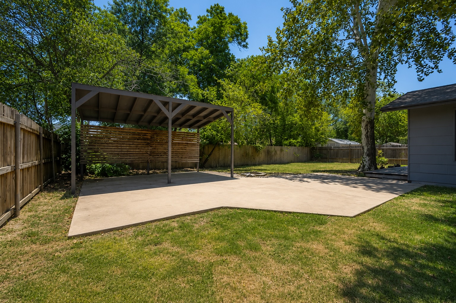 2105 Fortview Road Austin, TX 78704 - Photo 32 of 37 A spacious backyard features a concrete patio and a shaded pergola for outdoor enjoyment.