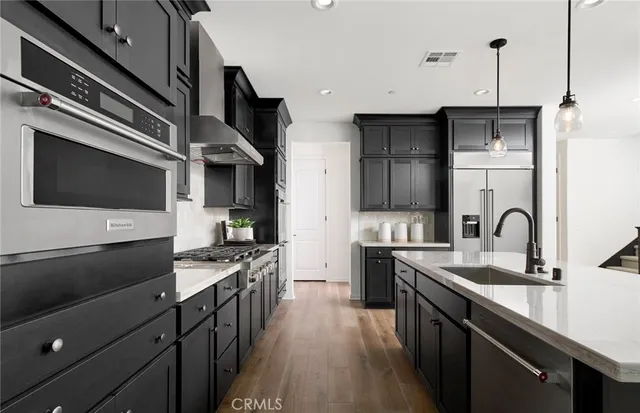 a kitchen with stainless steel appliances a sink stove and refrigerator