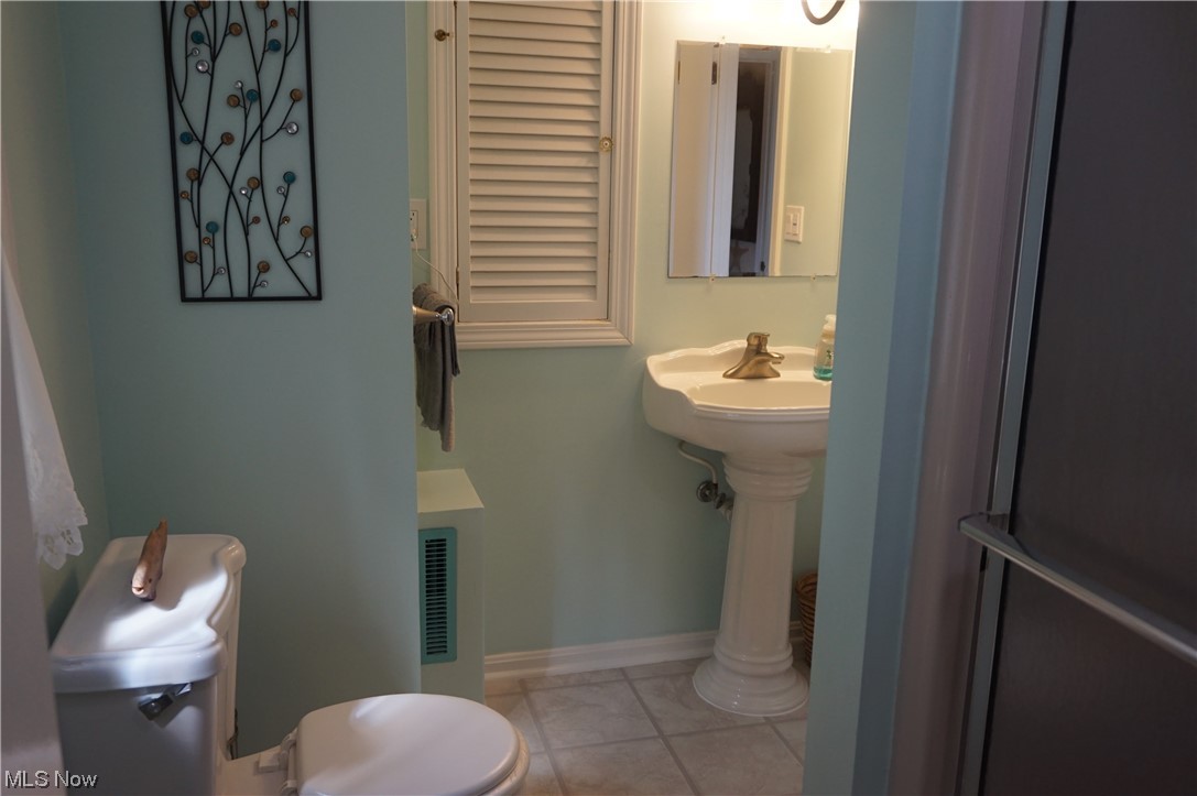7311 Lake Road East Madison, OH 44057 - Photo 19 of 35 Bathroom featuring pedestal sink, shower and entry to the master bedroom and hall access.