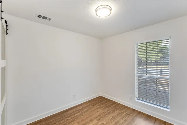 a view of a yard with potted plants and large trees